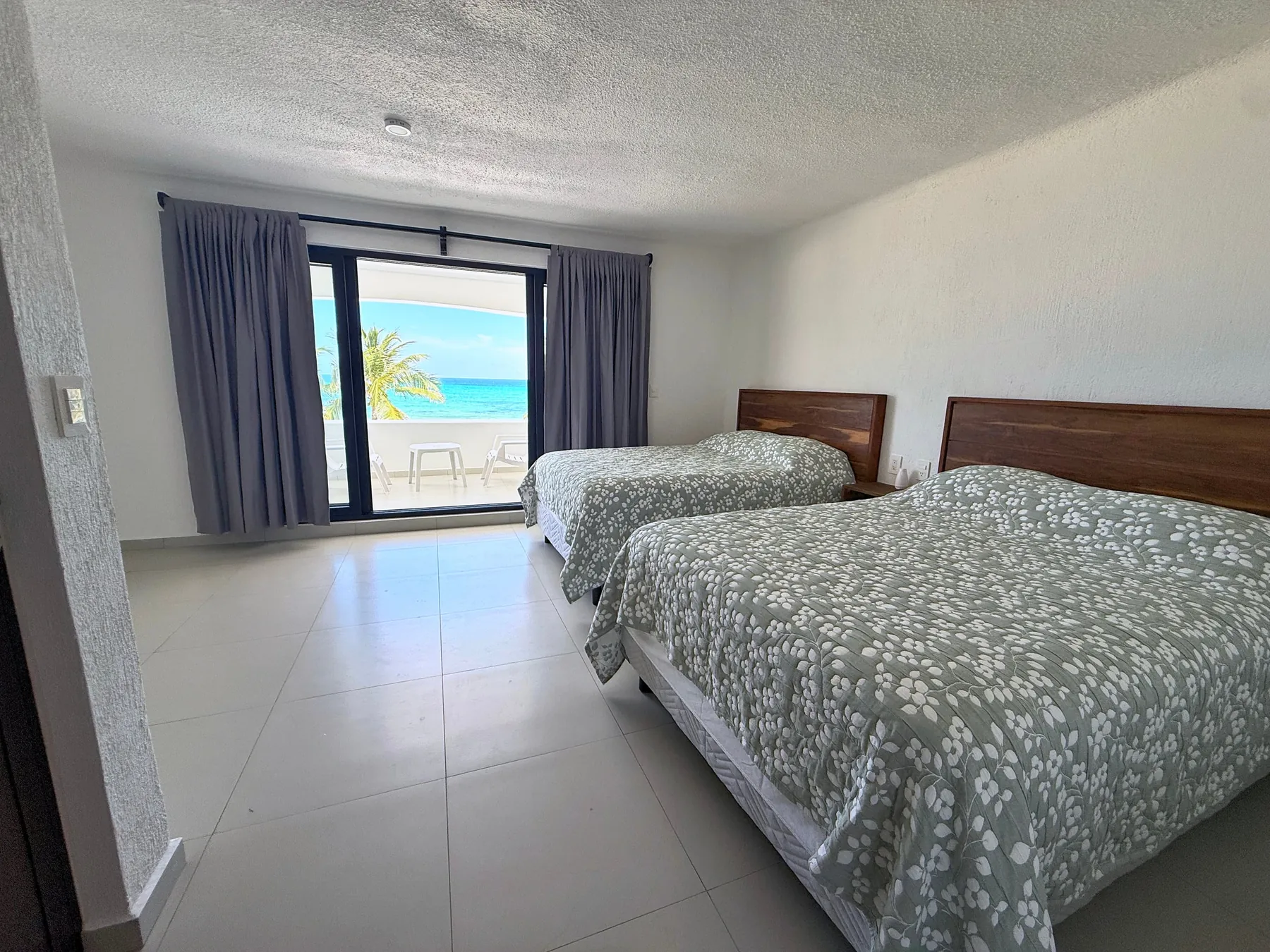 Bedroom 3 with two double beds and a view of the sea