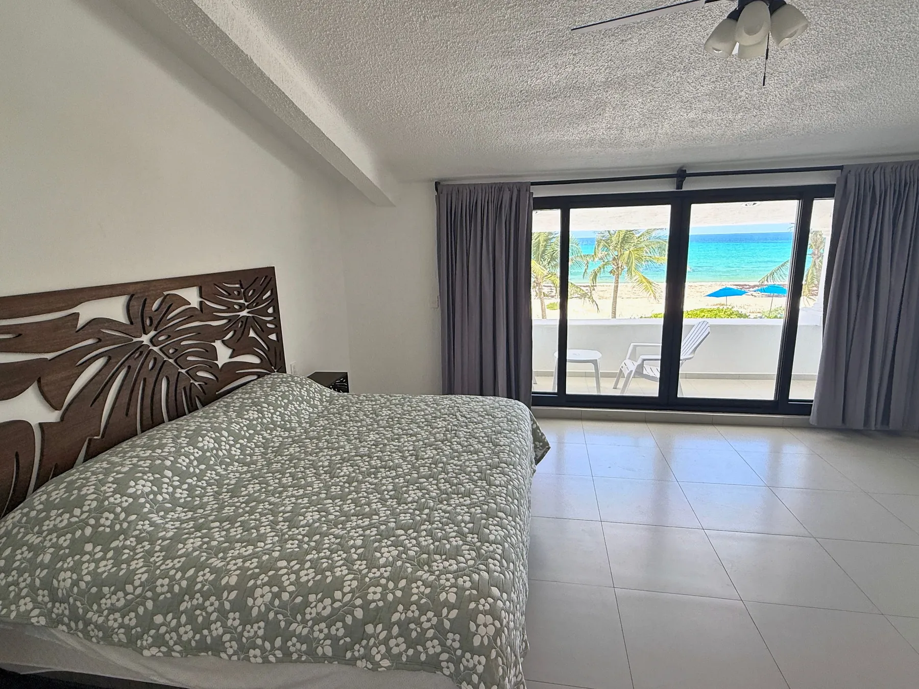 Bedroom 1 with a king bed and doors to a sea-view terrace