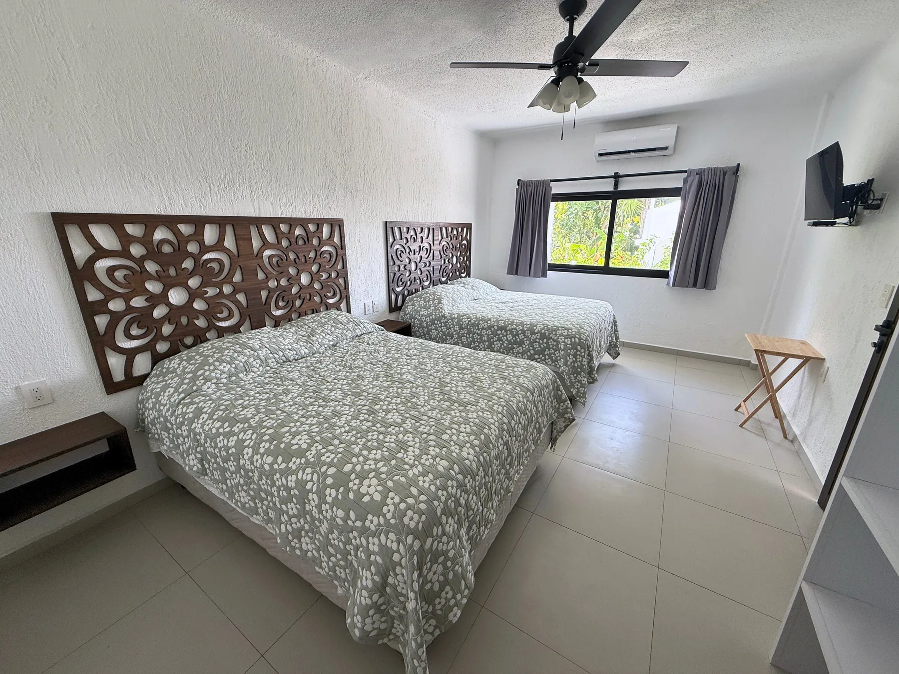 Bedroom 2 with carved headboards and a garden window